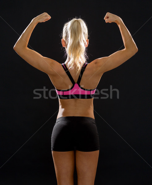 sporty woman from the back flexing her biceps Stock photo © dolgachov