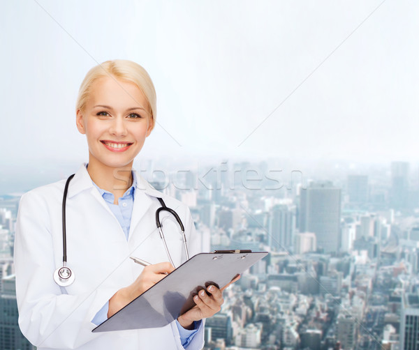 smiling female doctor with clipboard Stock photo © dolgachov