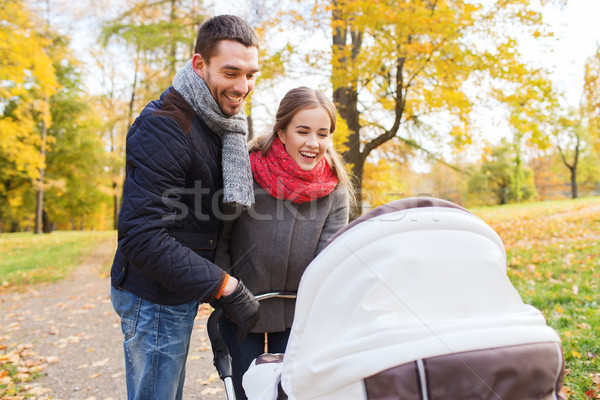 smiling couple with baby pram in autumn park Stock photo © dolgachov