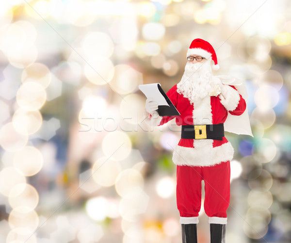 man in costume of santa claus with notepad and bag Stock photo © dolgachov