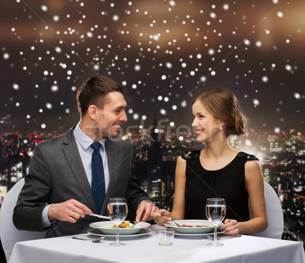 smiling couple eating main course at restaurant Stock photo © dolgachov
