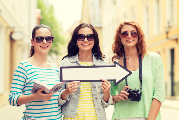 smiling teenage girls with white arrow outdoors Stock photo © dolgachov