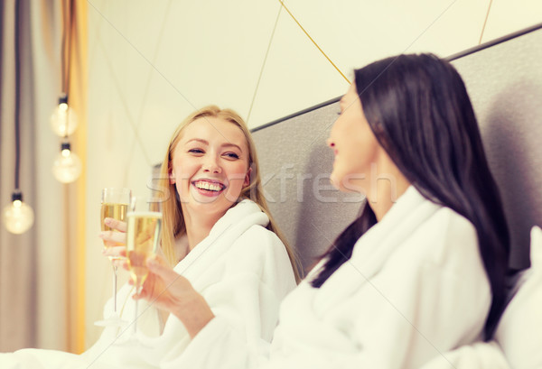 smiling girlfriends with champagne glasses in bed Stock photo © dolgachov