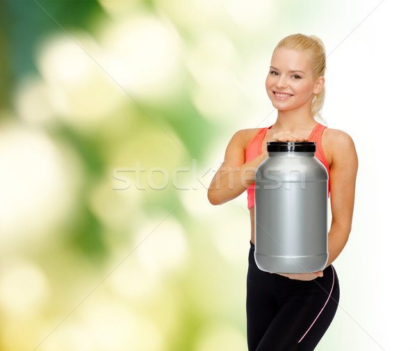 smiling sporty woman with jar of protein Stock photo © dolgachov