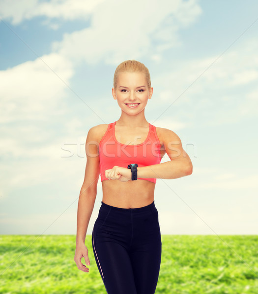 Glimlachende vrouw hartslag monitor hand fitness technologie Stockfoto © dolgachov