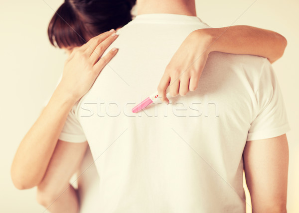 Stock photo: woman with pregnancy test hugging man