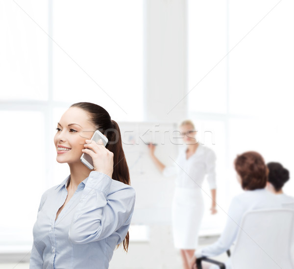 Stock photo: young smiling businesswoman with smartphone