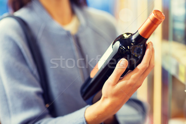 Stock photo: happy woman choosing and buying wine in market
