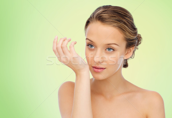 woman smelling perfume from wrist of her hand Stock photo © dolgachov