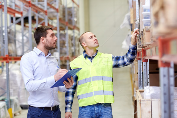 Stock photo: worker and businessmen with clipboard at warehouse