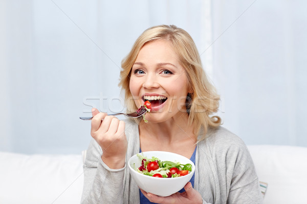 smiling middle aged woman eating salad at home Stock photo © dolgachov