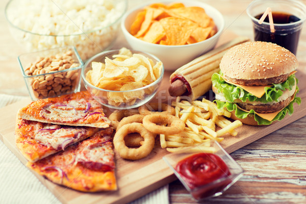 close up of fast food snacks and drink on table Stock photo © dolgachov
