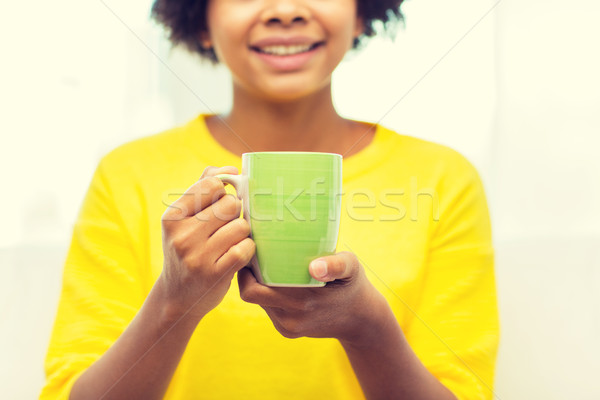 happy african american woman drinking from tea cup Stock photo © dolgachov