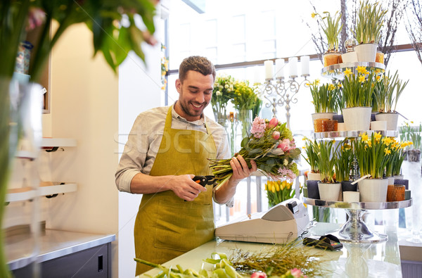 smiling florist man making bunch at flower shop Stock photo © dolgachov