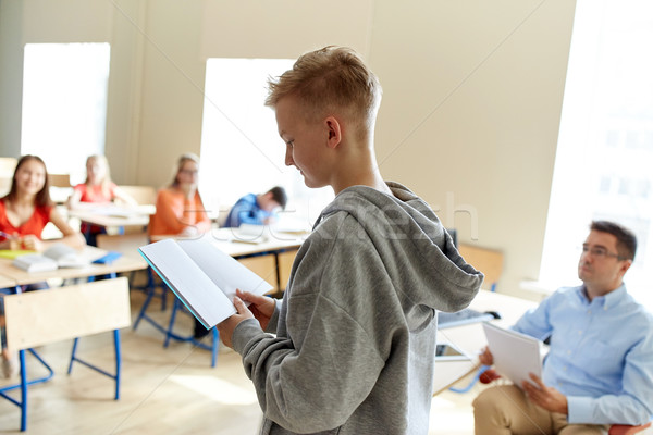 student boy with notebook and teacher at school Stock photo © dolgachov