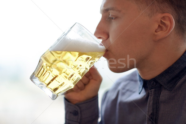 close up of young man drinking beer from glass mug Stock photo © dolgachov
