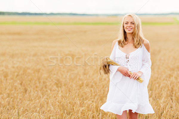 happy young woman with spikelets on cereal field Stock photo © dolgachov