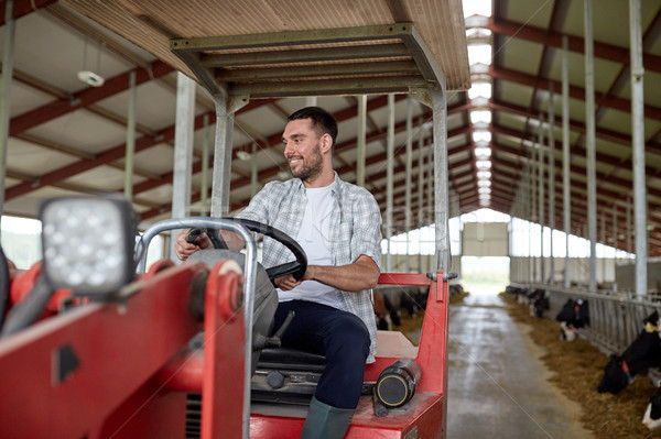 man or farmer driving tractor at farm Stock photo © dolgachov