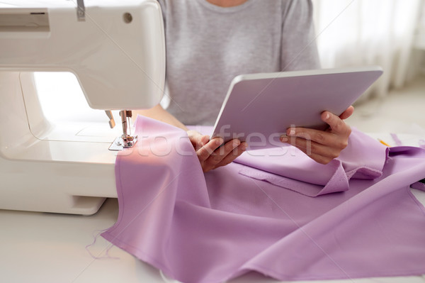 Stock photo: tailor with sewing machine, tablet pc and fabric