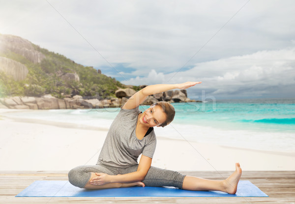 happy woman doing yoga and stretching on beach Stock photo © dolgachov