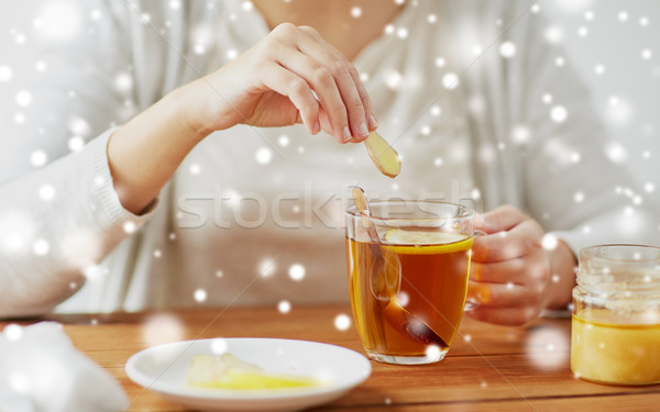 close up of woman adding honey to tea with lemon Stock photo © dolgachov