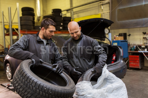 auto mechanics changing car tires at workshop Stock photo © dolgachov
