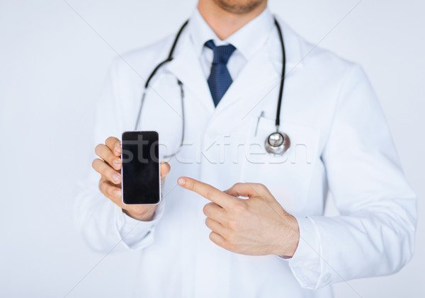 doctor pointing at smartphone Stock photo © dolgachov