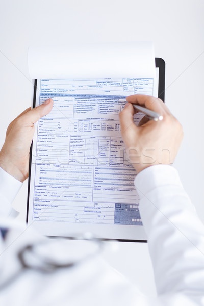 male doctor holding prescription paper in hand Stock photo © dolgachov