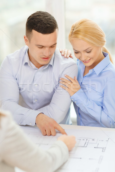 smiling couple looking at blueprint Stock photo © dolgachov