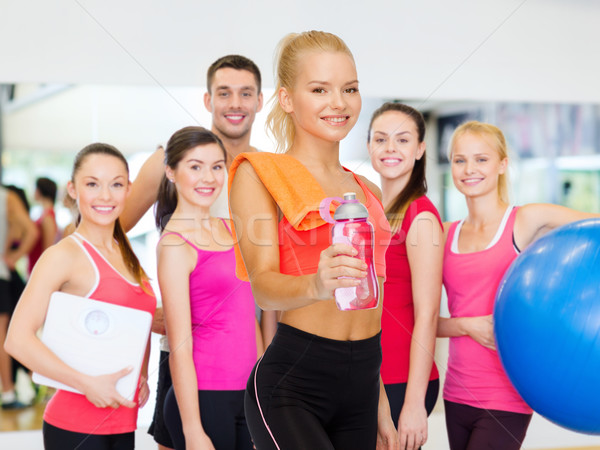 smiling sporty woman with water bottle and towel Stock photo © dolgachov