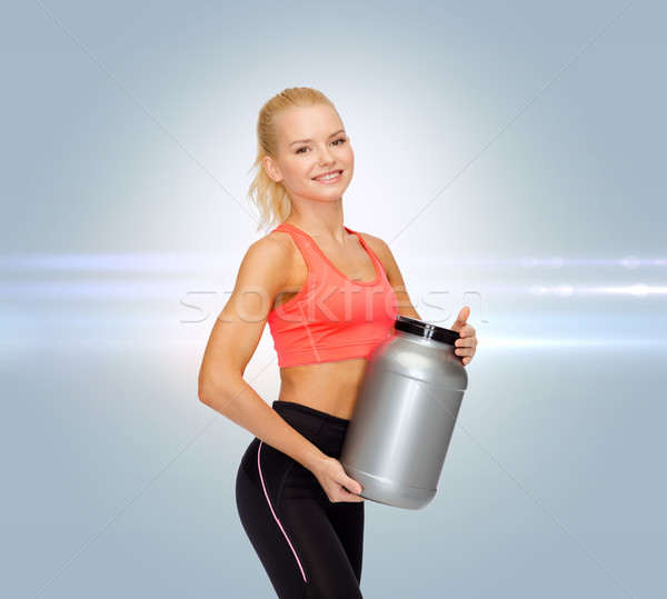 smiling sporty woman with jar of protein Stock photo © dolgachov