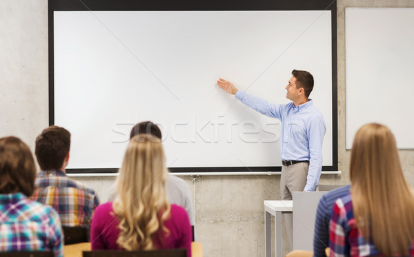 group of students and smiling teacher in classroom Stock photo © dolgachov