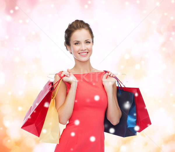 smiling elegant woman in dress with shopping bags Stock photo © dolgachov