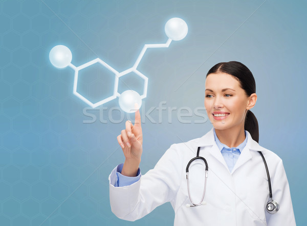 smiling female doctor pointing to molecule Stock photo © dolgachov