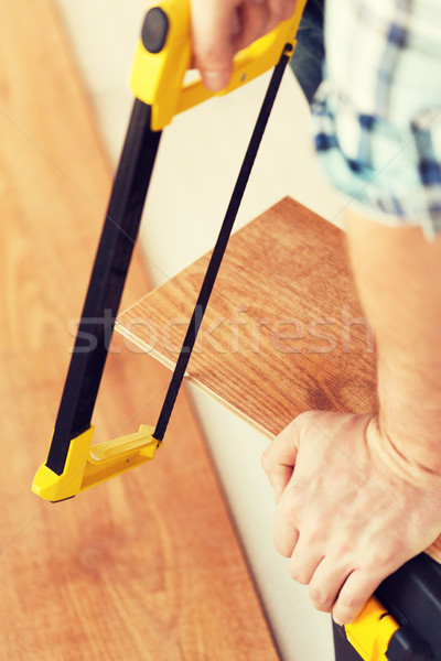close up of male hands cutting parquet floor board Stock photo © dolgachov