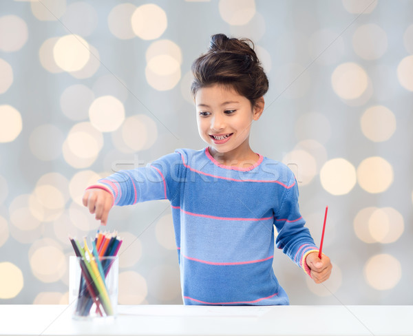 happy little girl drawing with coloring pencils Stock photo © dolgachov