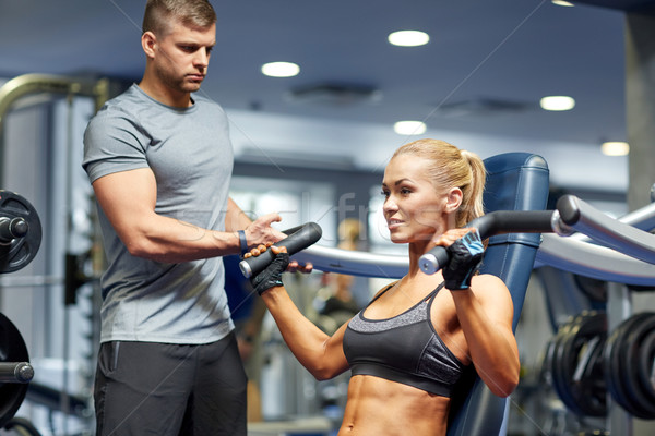 man and woman flexing muscles on gym machine Stock photo © dolgachov