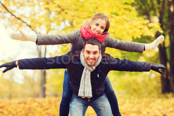 Stock photo: smiling couple having fun in autumn park