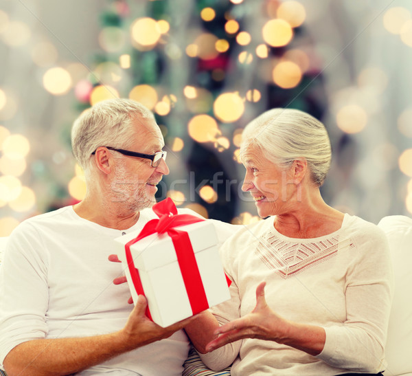 happy senior couple with gift box at home Stock photo © dolgachov