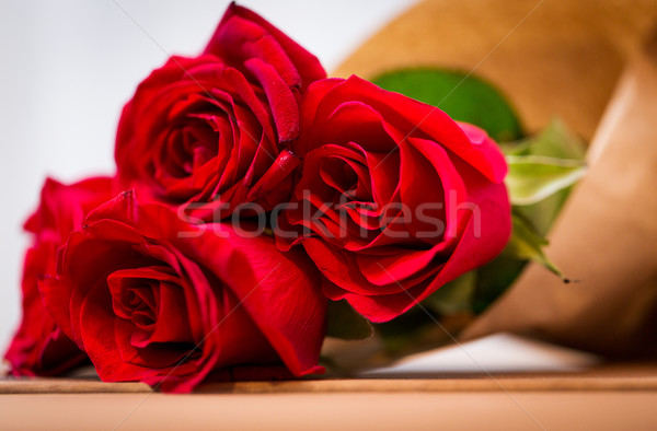 close up of red roses bunch wrapped into paper Stock photo © dolgachov