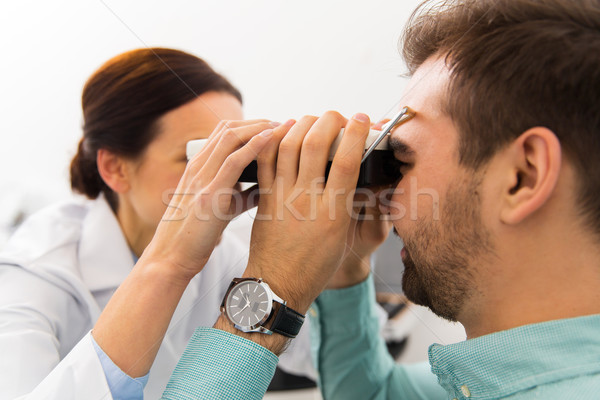 optician with pupillometer and patient at clinic Stock photo © dolgachov