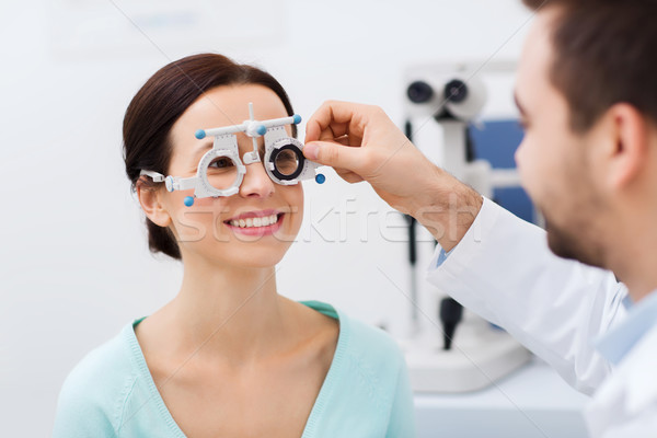 optician with trial frame and patient at clinic Stock photo © dolgachov