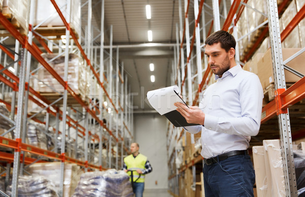 Stock photo: businessman writing to clipboard at warehouse