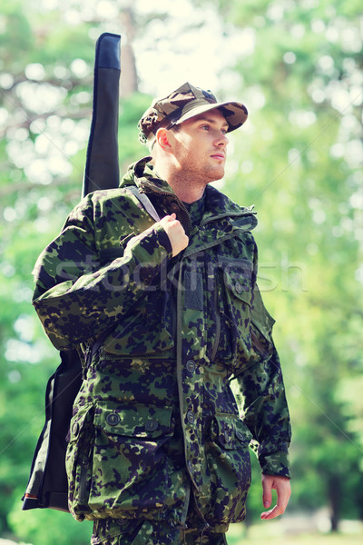young soldier or hunter with gun in forest Stock photo © dolgachov