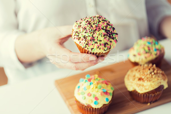 close up of woman with glazed cupcakes or muffins Stock photo © dolgachov