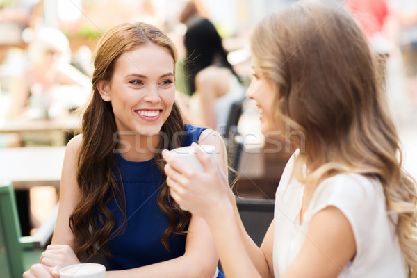 Foto stock: Sorridente · mulheres · jovens · xícaras · de · café · café · comunicação · amizade