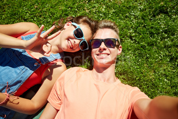 happy teenage couple taking selfie on summer grass Stock photo © dolgachov