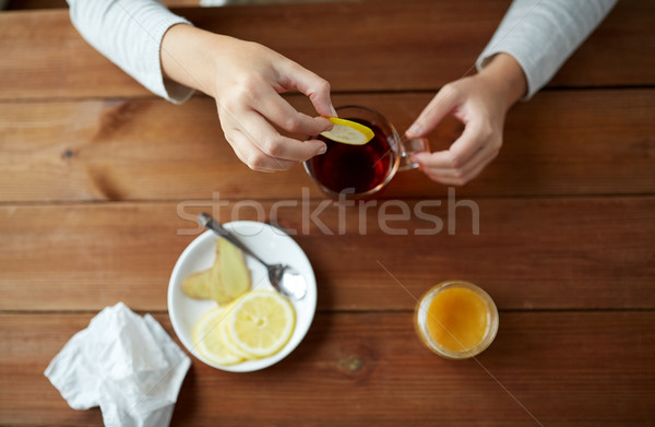 close up of woman adding lemon to tea cup Stock photo © dolgachov