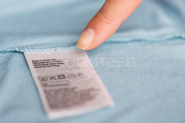Stock photo: finger pointing to users manual of clothing