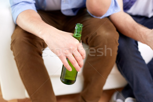 Hommes bière bouteilles séance canapé maison [[stock_photo]] © dolgachov